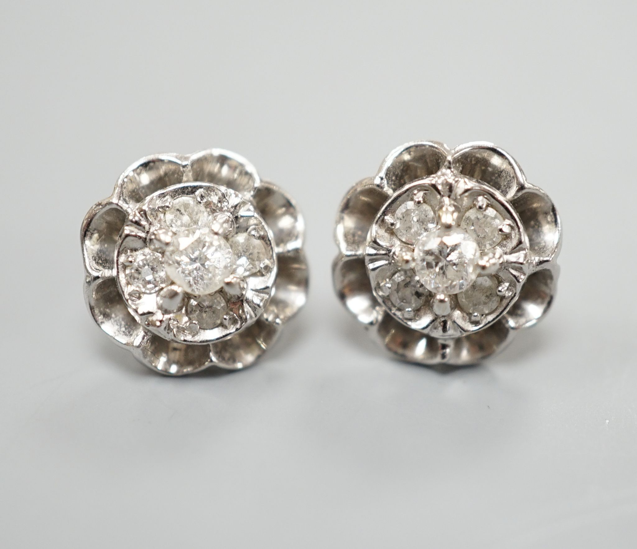 A pair of 750 white metal and five stone diamond cluster set earrings, 10mm, gross weight 3.2 grams.